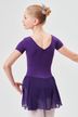 Ein junges Mädchen in einem lila Ballettbody und Rock posiert in einer Balletthaltung und blickt von der Kamera weg. 2