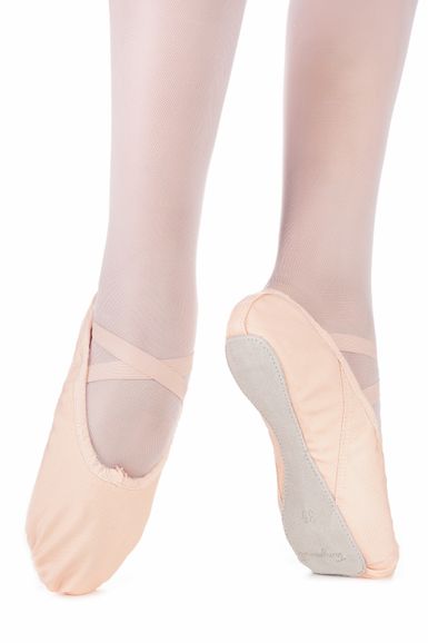 Nahaufnahme der Füße einer Tänzerin in hellrosa Ballettschuhen und Strumpfhosen