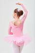 Junges Mädchen in einem rosa Ballett-Outfit und Tutu posiert mit einem erhobenen Arm und blickt von der Kamera weg. 2
