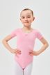 Ein junges Mädchen in einem rosa Ballettbody und weißen Strumpfhosen steht mit den Händen in den Hüften. 1