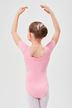 Ein junges Mädchen in einem rosa Ballettbody und weißen Strumpfhosen steht mit erhobenen Armen da 2