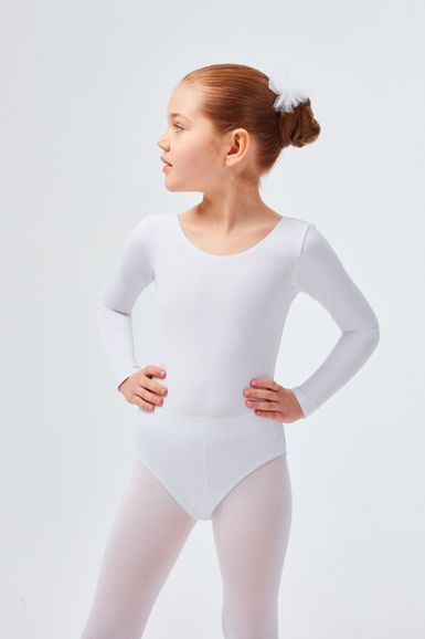 Ein junges Mädchen in einem weißen Ballettbody und Strumpfhosen steht mit den Händen in den Hüften und blickt zur Seite.