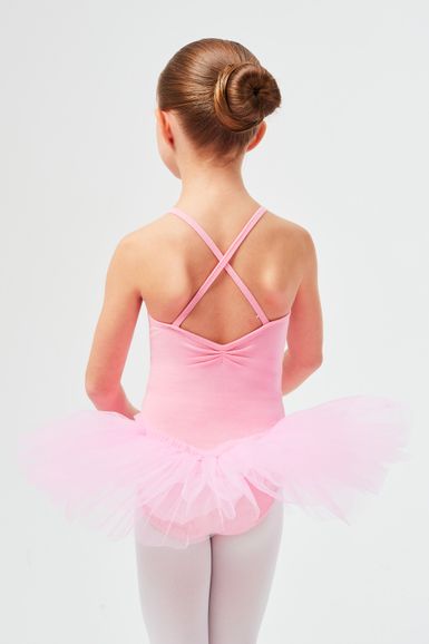 Junges Mädchen in einem rosa Tutu und Ballettanzug mit Duttfrisur