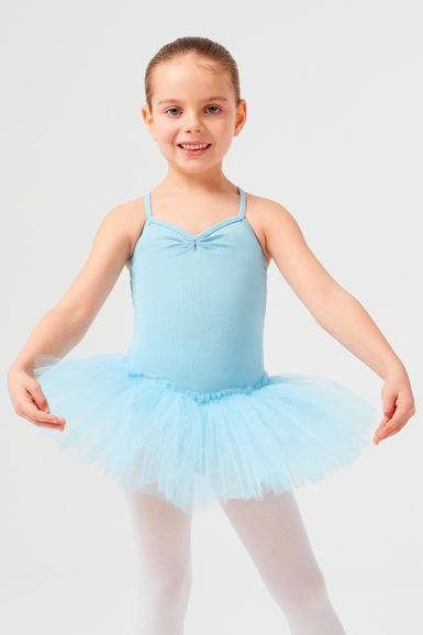 Ein junges Mädchen in einem hellblauen Ballett-Outfit und weißen Strumpfhosen steht in einer Ballettpose.