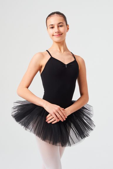Eine junge Balletttänzerin in einem schwarzen Ballettbody und Tutu posiert mit gefalteten Händen.