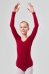 Ein junges Mädchen in einem roten Ballettbody steht mit erhobenen Armen in einer Ballettpose. 3