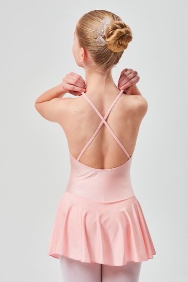 Ein Mädchen in einem rosa Ballettkleid steht mit dem Rücken zur Kamera und hält mit beiden Händen die Träger ihres Kleides.