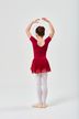 Ein junges Mädchen in einem roten Ballett Trikot und Rock posiert in Ballettposition mit erhobenen Armen und dem Rücken zur Kamera. 4