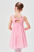 Ein junges Mädchen in einem rosa Ballettkleid steht mit hinter dem Rücken verschränkten Händen da und blickt von der Kamera weg. 2