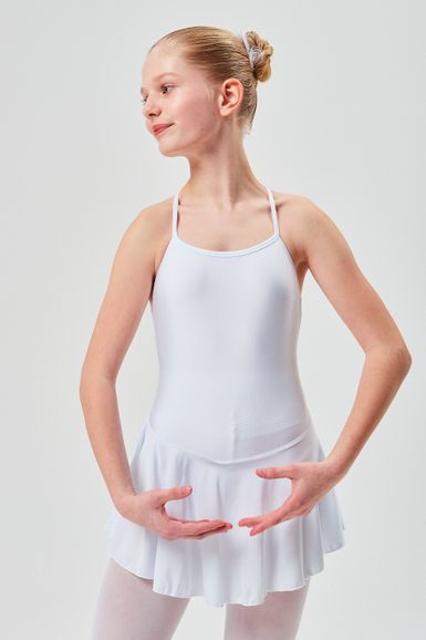 Ein junges Mädchen in einem weißen Ballett-Outfit steht mit den Armen in einer Ballettpose.
