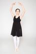 Ein Mädchen in einem schwarzen Kleid und weißen Strumpfhosen posiert in einer Ballettposition. 3