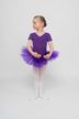 Ein junges Mädchen in einem lila Ballett Trikot und Tutu steht in einer Ballettpose. 3