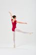 Balletttänzerin in einem roten Ballett Trikot und weißen Strumpfhosen balanciert auf einem Bein mit ausgestreckten Armen und blickt auf einen weißen Hintergrund. 4