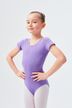 Ein junges Mädchen in einem lila Ballett Trikot und weißen Strumpfhosen steht selbstbewusst mit den Händen in den Hüften. 1