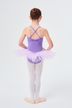 Ein junges Mädchen in einem lila Ballett Trikot und Tutu steht in Ballettposition und blickt von der Kamera weg auf einem weißen Hintergrund. 4