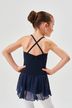 Ein junges Mädchen in einem marineblauen Ballettkleid mit überkreuzten Trägern steht mit den Händen in den Hüften und blickt von der Kamera weg. 2