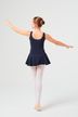 Eine junge Balletttänzerin in einem marineblauen Ballett Trikot und weißen Strumpfhosen steht mit ausgestreckten Armen da und blickt von der Kamera weg. 4