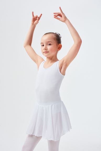 Junges Mädchen in einem weißen Ballett-Outfit posiert mit erhobenen Armen.