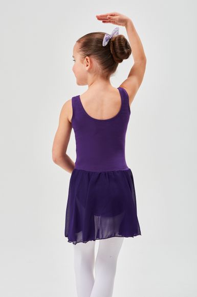 Ein junges Mädchen in einem lila Ballett Trikot und Rock posiert mit einem erhobenen Arm und dem Rücken zur Kamera.