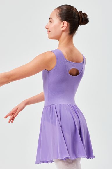 Ein Mädchen in einem lavendelfarbenen Ballettkleid steht in einer Tanzpose mit ausgestreckten Armen und einem ordentlichen Dutt im Haar.