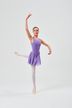 Eine Balletttänzerin in einem lila Ballett Trikot und Rock posiert auf einem Bein. 3
