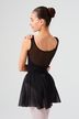 Eine junge Balletttänzerin in einem schwarzen Ballett Trikot und Rock steht mit einer Hand auf der Schulter und blickt abgewandt. 2