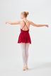 Eine Balletttänzerin in einem roten Kleid und weißen Strumpfhosen steht in einer Pose mit ausgestreckten Armen 4