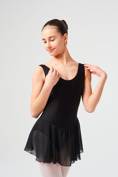 Eine junge Frau in einem schwarzen Ballett Trikot und Rock posiert anmutig.