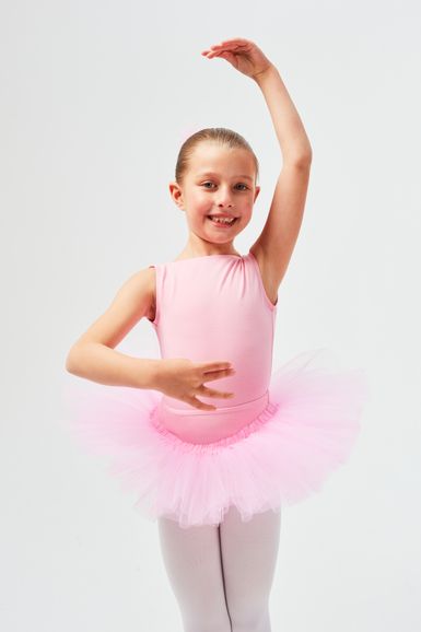 Junges Mädchen in einem rosa Ballett-Tutu und Strumpfhosen posiert mit einem erhobenen Arm.