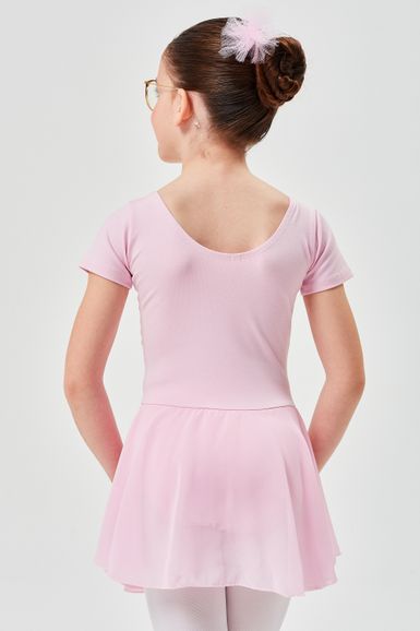 Junges Mädchen mit braunem Haar im Dutt und rosa Ballett-Outfit