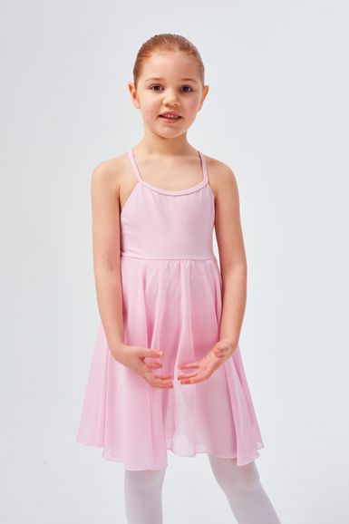 Ein junges Mädchen in einem rosa Ballettkleid und weißen Strumpfhosen steht mit für das Ballett positionierten Armen.