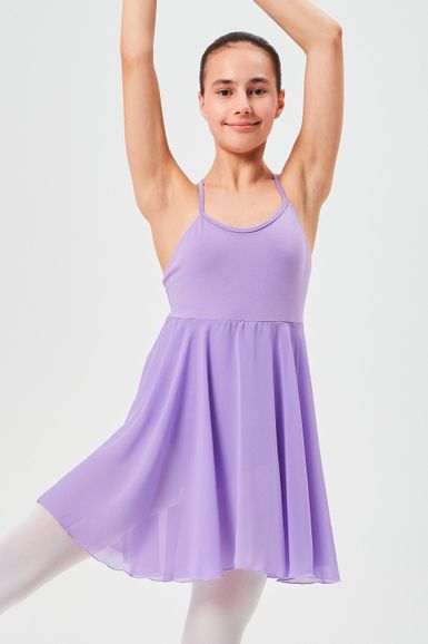 Eine junge Person in einem lavendelfarbenen Ballettkleid posiert mit erhobenen Armen.