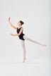Eine Balletttänzerin in einem schwarzen Ballett Trikot und weißen Strumpfhosen balanciert in einer Arabeskenpose. 3