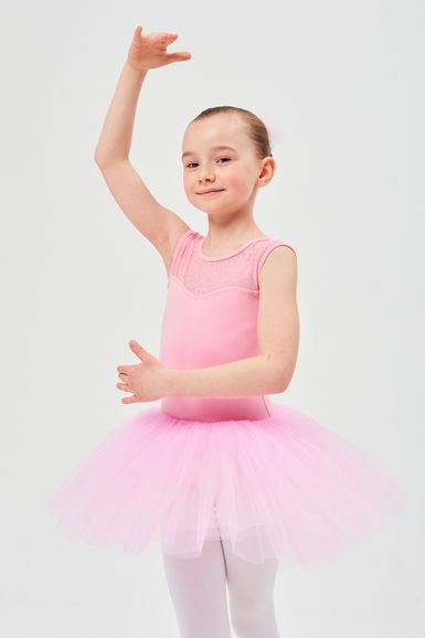 Ein junges Mädchen in einem rosa Ballettkostüm posiert mit einem erhobenen Arm.