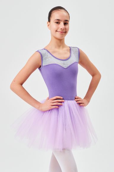 Ein junges Mädchen in einem lavendelfarbenen Ballett-Tutu posiert mit den Händen in den Hüften.