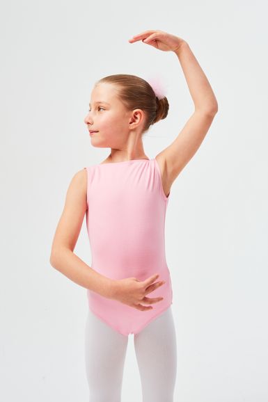 Ein junges Mädchen in einem rosa Ballett Trikot posiert in einer Ballettposition.