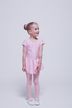 Ein junges Mädchen in einem rosa Ballett-Outfit steht vor einem schlichten Hintergrund 3