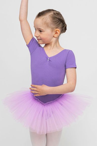 Ein junges Mädchen in einem lila Ballett Trikot und Tutu posiert mit einem erhobenen Arm und blickt zur Seite.