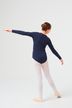 Ein junges Mädchen im Ballettkleid steht mit ausgestreckten Armen auf einem Bein und blickt von der Kamera weg. 4