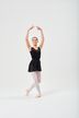 Eine Balletttänzerin in einem schwarzen Ballett Trikot und weißen Strumpfhosen posiert mit erhobenen Armen. 3