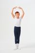 Ein kleiner Junge in Ballettkleidung steht mit über den Kopf erhobenen Armen in einer Ballettpose.