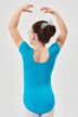 Mädchen in einem blauen Ballett Trikot und einer Schleife steht mit erhobenen Armen 2