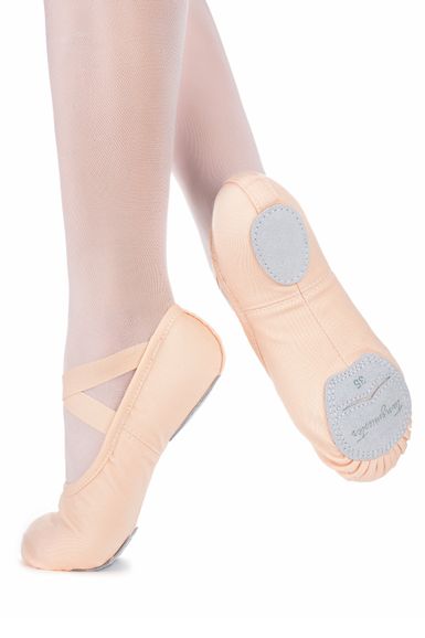 Eine Tänzerin in hellrosa Strumpfhosen und pfirsichfarbenen Ballettschuhen steht mit gestrecktem Fuß und angehobener Ferse da.