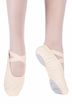 Eine Person trägt rosa Ballettschuhe und Strumpfhosen und steht mit einem Fuß flach auf dem Boden und dem anderen gestreckt da.