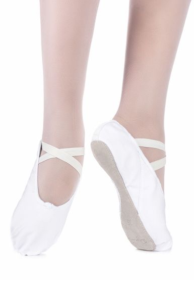 Zwei Füße in hellrosa Strumpfhosen und weißen Ballettschuhen mit elastischen Riemen stehen auf einem weißen Hintergrund.