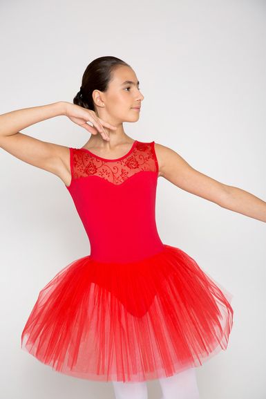 Eine junge Balletttänzerin in einem roten Trikot und Tutu posiert.