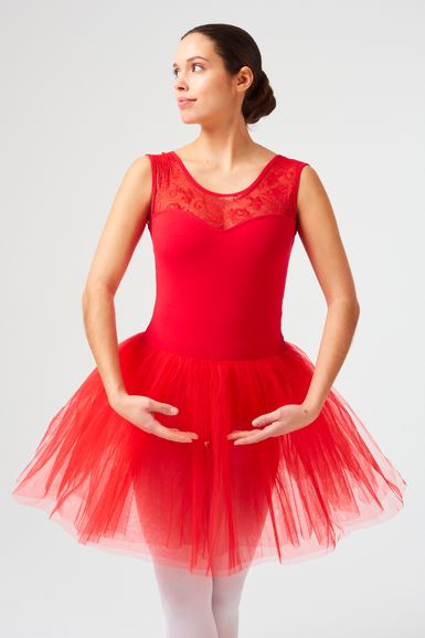 Eine Frau in einem roten Ballett-Tutu posiert in erster Position.