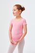 Ein junges Mädchen in einem rosa Ballettbody und weißen Strumpfhosen steht und blickt zur Seite. 1