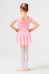 Ein junges Mädchen in einem rosa Ballett-Outfit steht mit den Händen in den Hüften und dem Gesicht abgewandt. 4