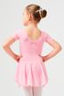 Ein junges Mädchen in einem rosa Ballettkleid mit Duttfrisur steht mit den Händen in den Hüften und blickt von der Kamera weg. 2